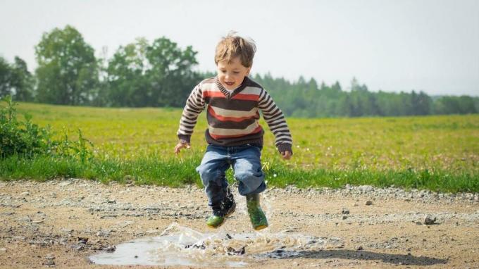 Αγόρι με ADHD που πηδά σε μια λακκούβα λάσπης