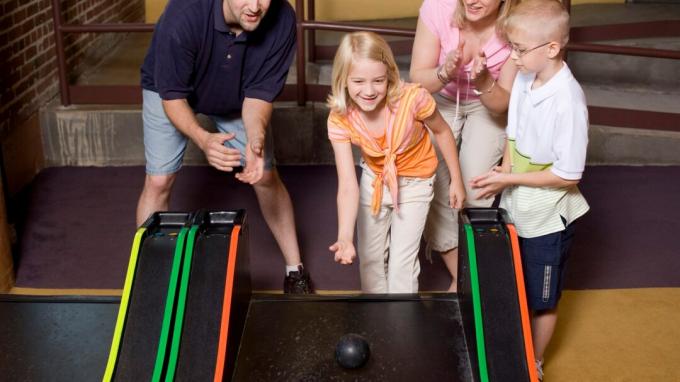 Μια ευτυχισμένη οικογένεια ξοδεύοντας χρόνο μαζί και παίζοντας παιχνίδια σε στοά, χάρη στη θετική γονική μέριμνα